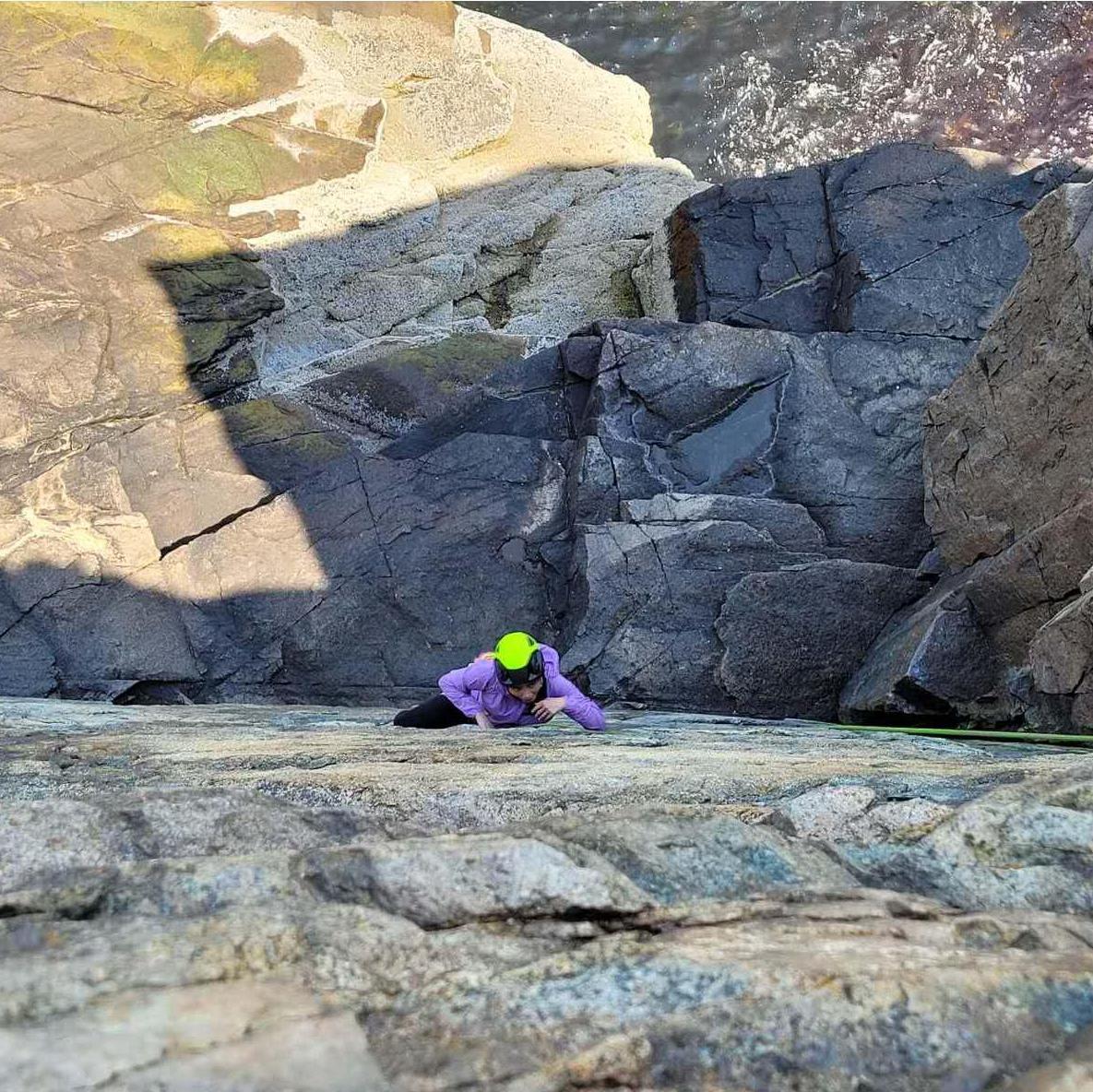 Sammi thinking about her climbing route in Otter Cliffs Acadia