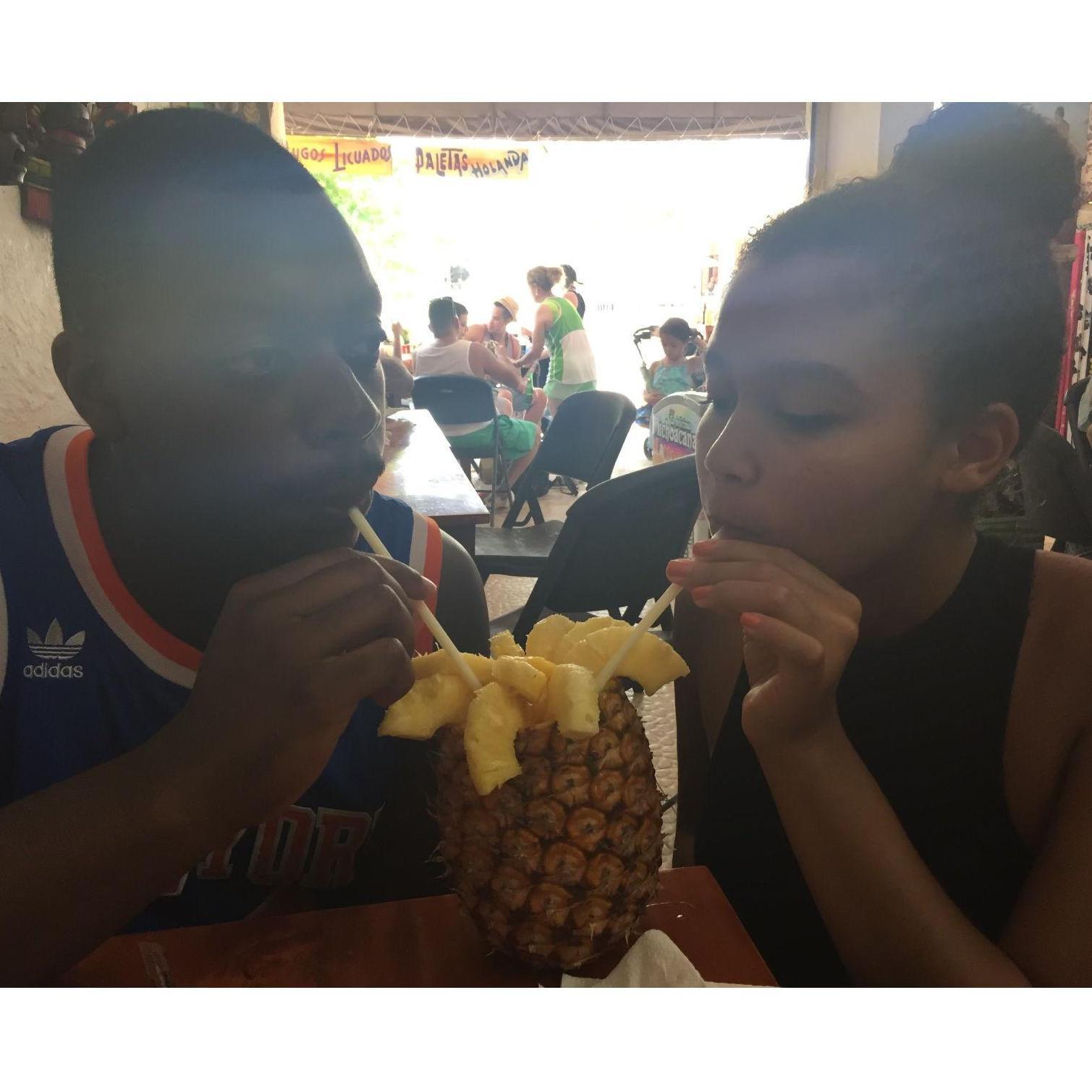 Sharing a drink from a pineapple in Cancun on our first international trip together.