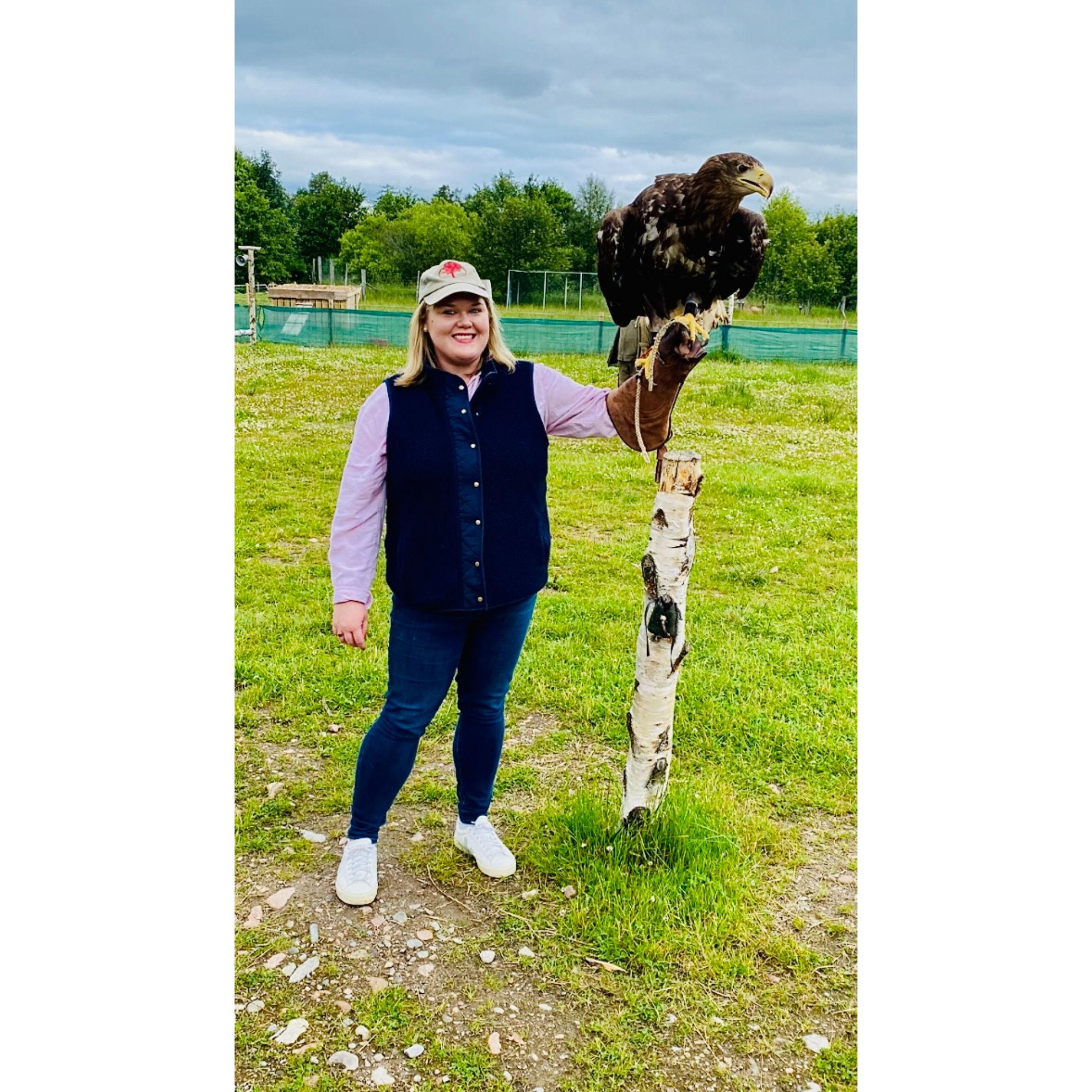 Satie holding a White Tailed eagle while taking falconry lessons in Aviemore, Scotland