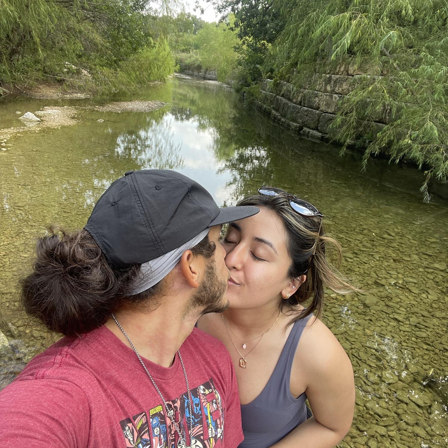Kisses in front of a creek in Austin, TX