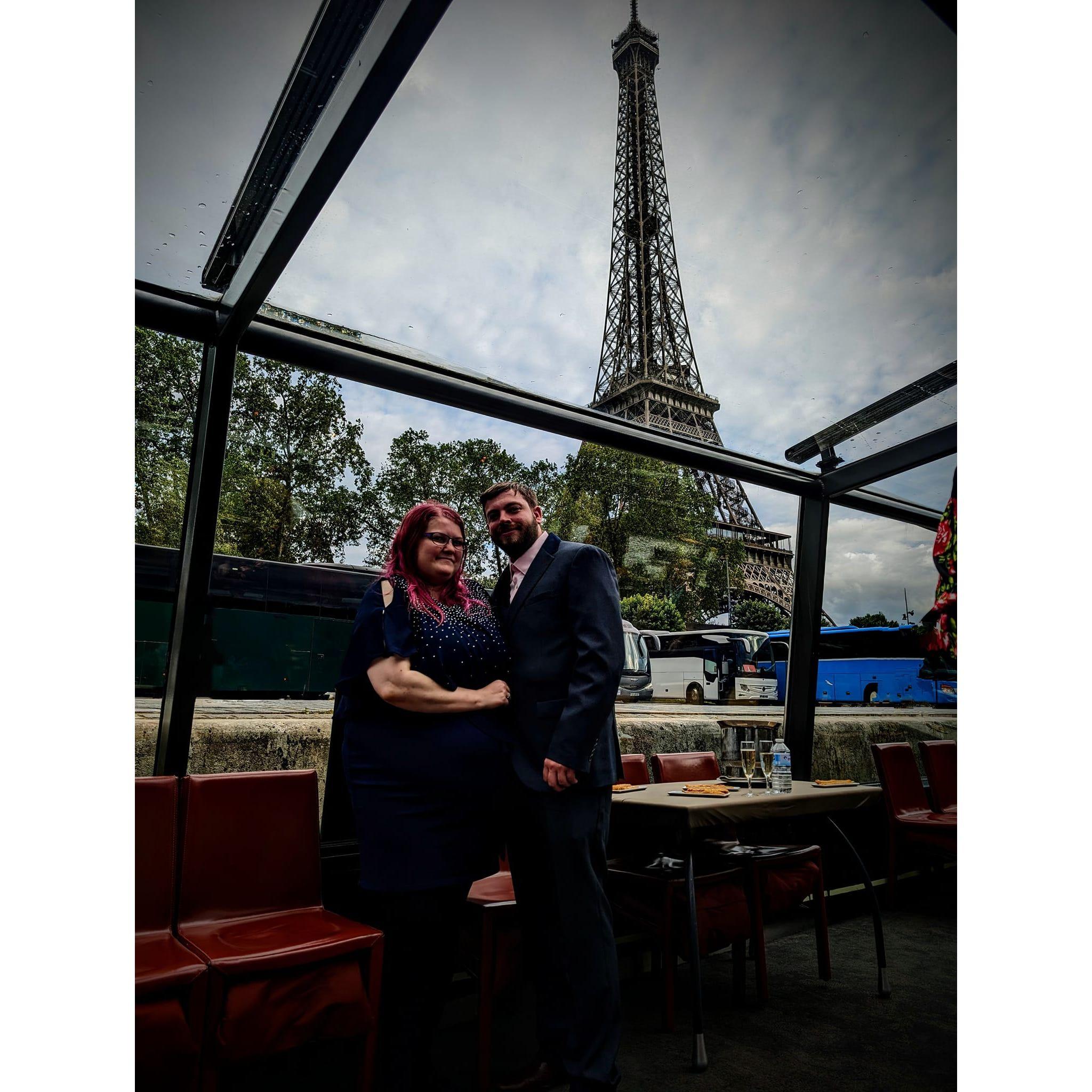 On a glass boat with the Eiffel tower in view.