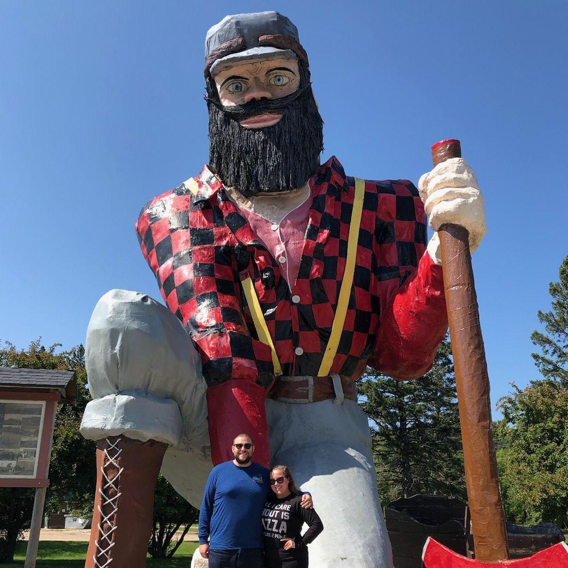 Hanging with our friend, Paul Bunyan!
Alt Text: Maeghan and Keiran posing together with a 30 foot statue of Paul Bunyan kneeling down, holding a hatchet and wearing a hat.