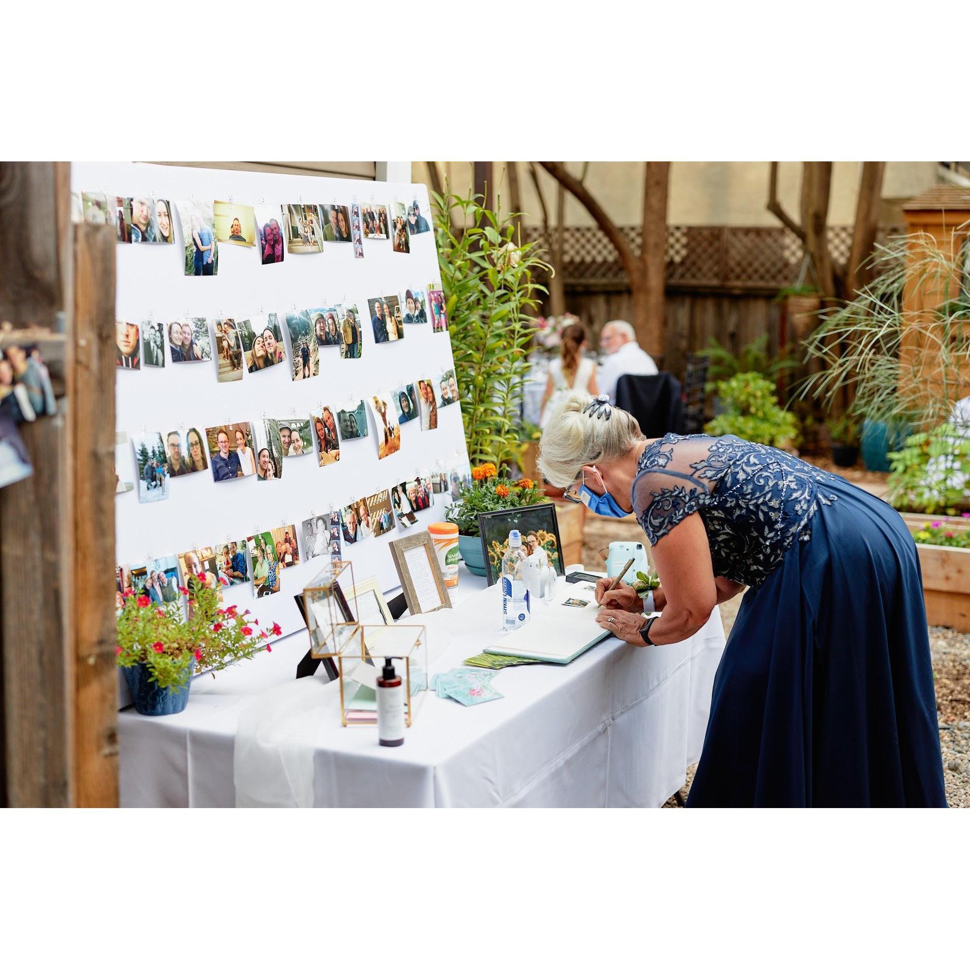 Rachel's mother, Betsy, signing the guest book on the welcome table, which was filled with photos of Rachel & Steve through the years