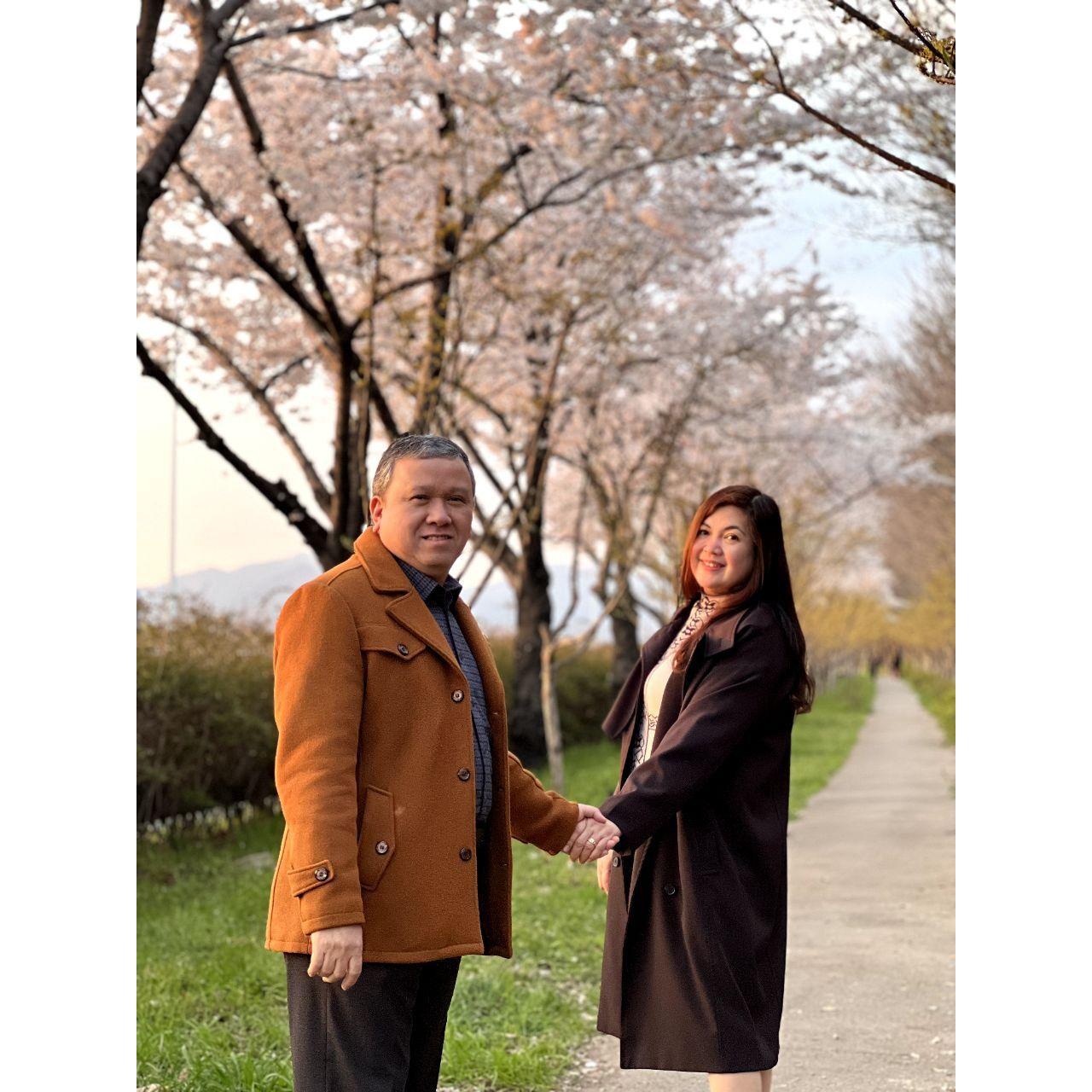 Hand in hand beneath the blossoms.