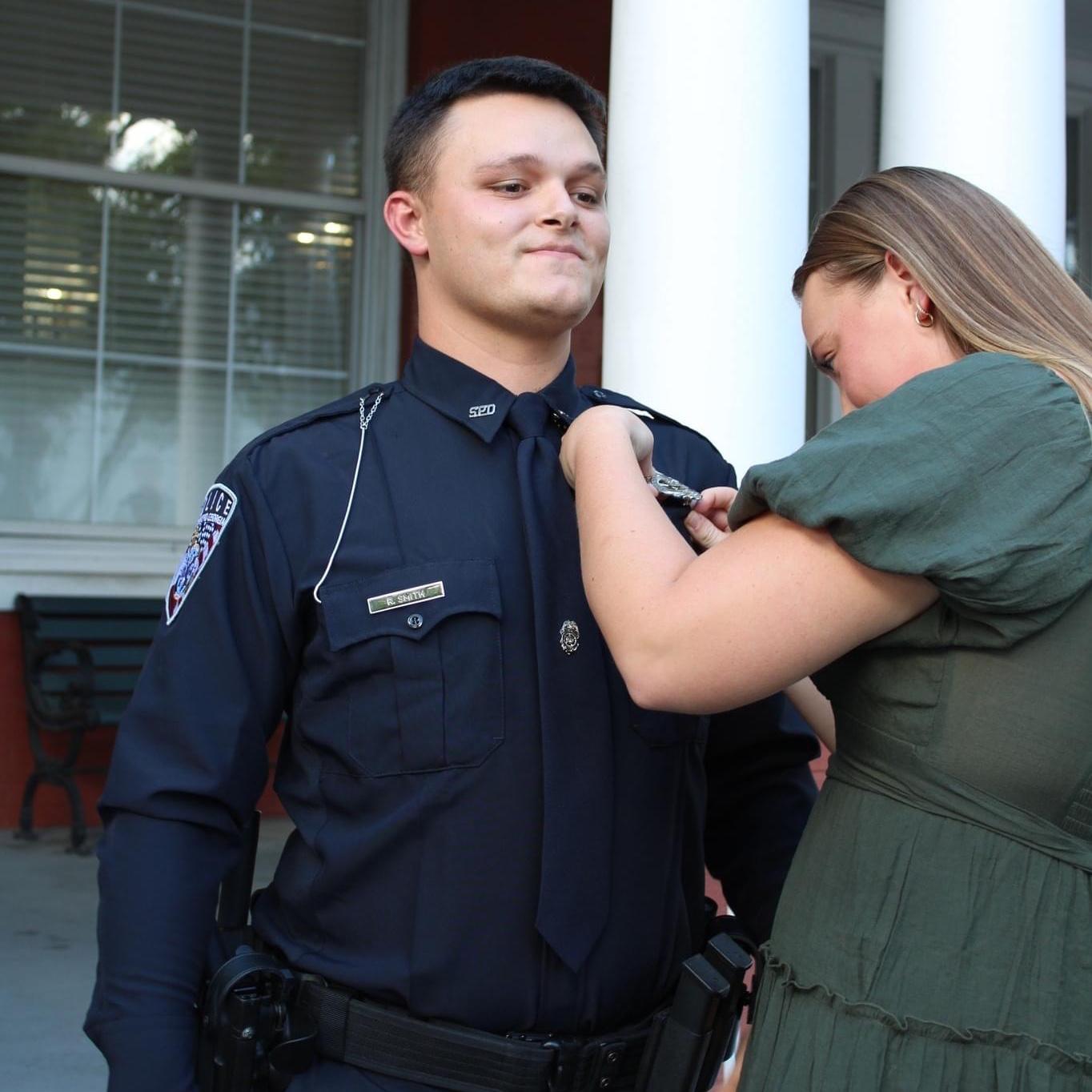 Pinning Ryan’s badge on him at his police academy graduation.