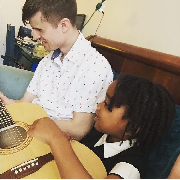 Ian teaching Gracie to play guitar