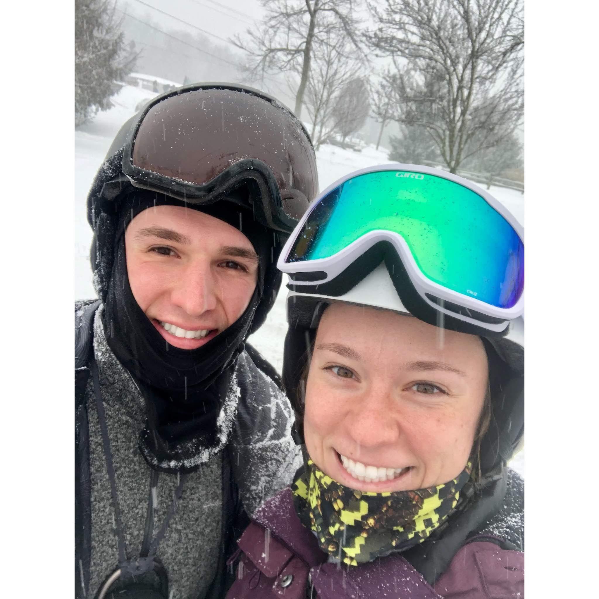 Tanner attempting to teach Meg to snowboard