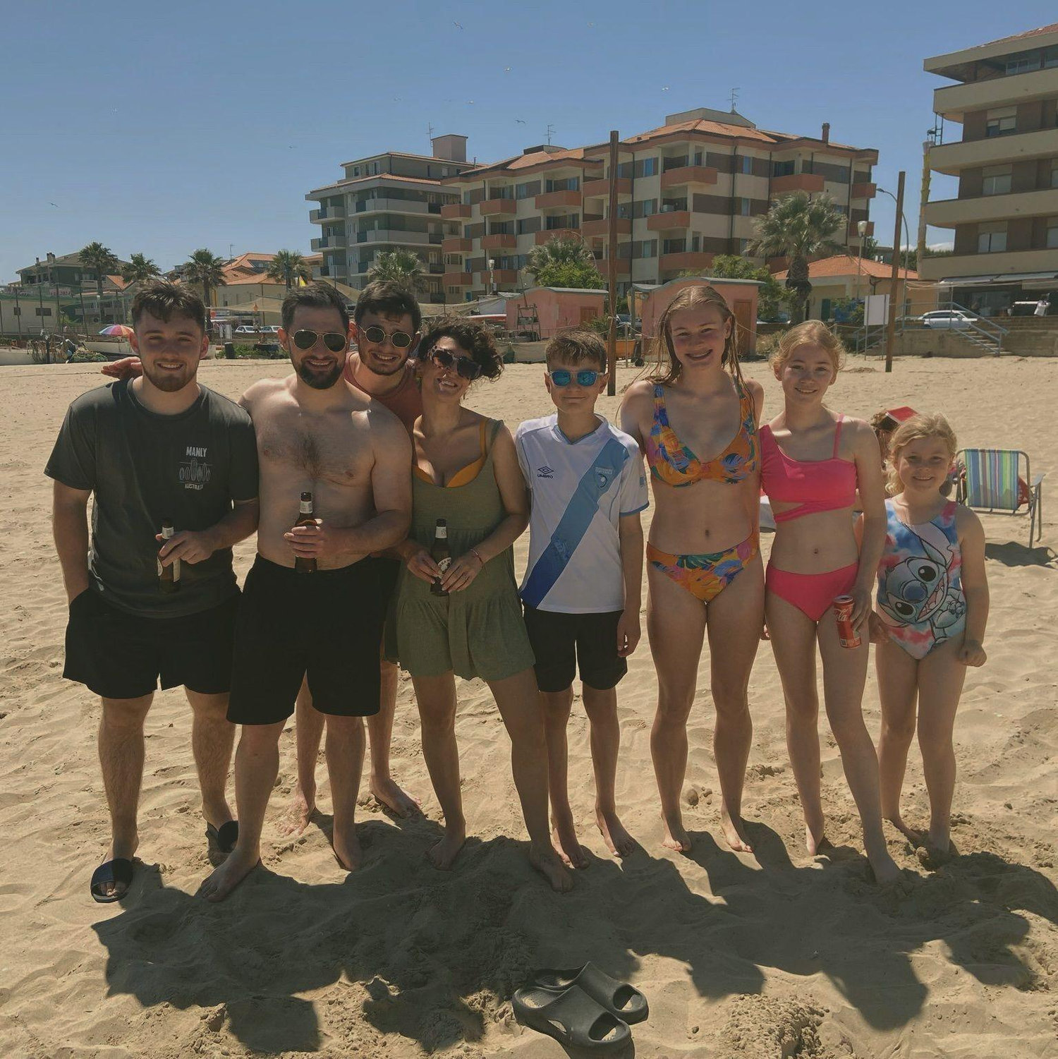 Family picture at the beach in Italy, the groom is the muscular handsome one in the middle holding again a diet coke. Yes the groom loves fizzy drinks!
