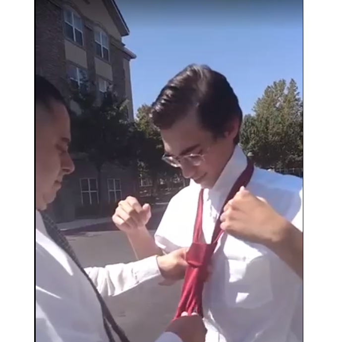 Clarissa's dad helping Donovan with his tie.