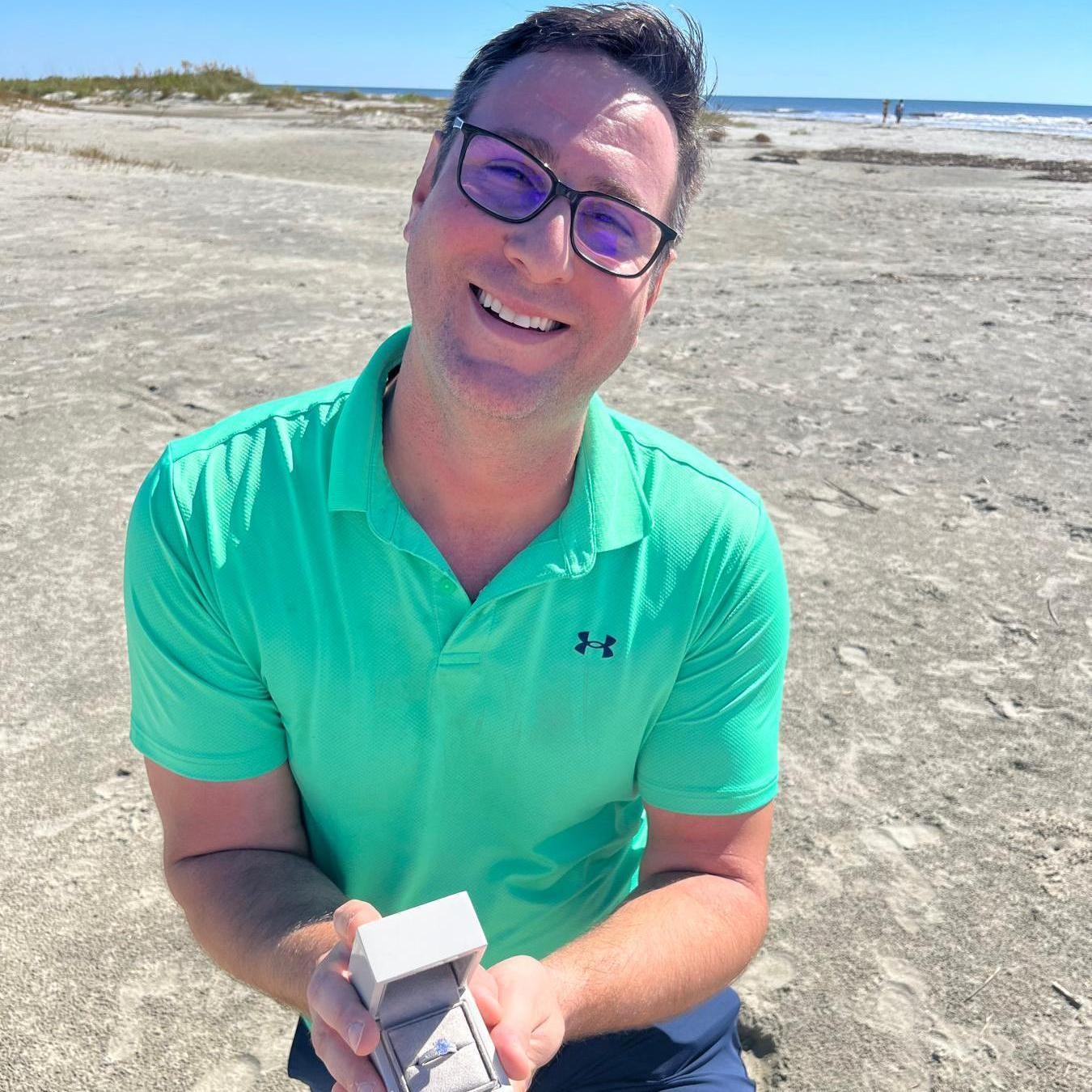 Enayat on one knee on Sullivan's Island, SC on October 16, 2022