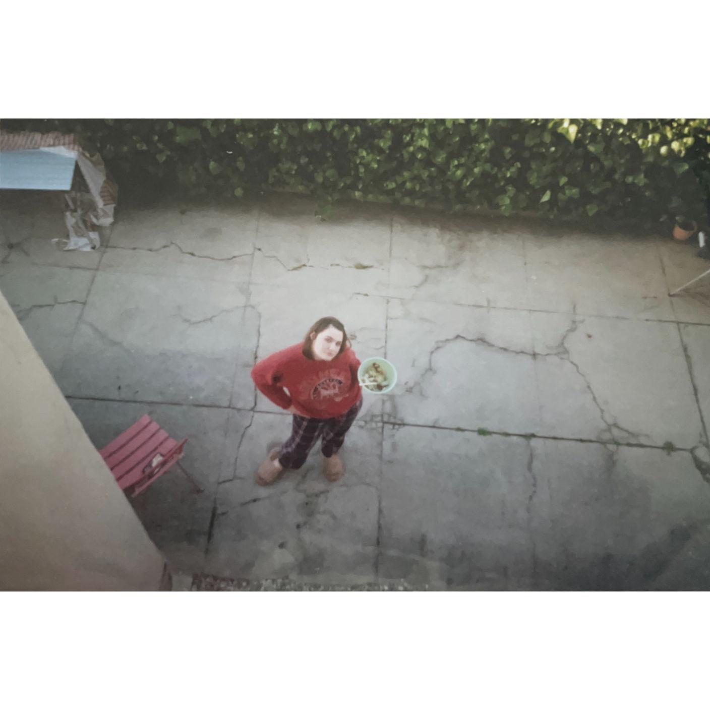 Natalie from out our bedroom window in our back patio watering our bell peppers and tomatoes