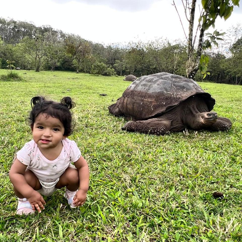 Galápagos Islands — Claire Hurtado enjoying the giant turtles. She’s smiling so much the turtles probably thought she was one of them… just a much faster one!