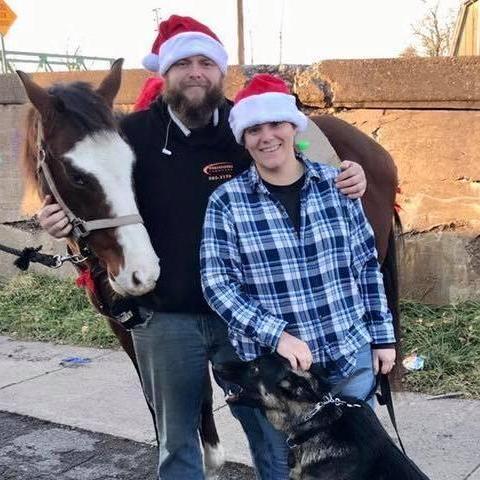 Our first holiday picture taken right before I rode Mister Dale (horse in photo) in the Brockport parade while Jon ran security animal management with Alastor our newest member of the family (puppy)