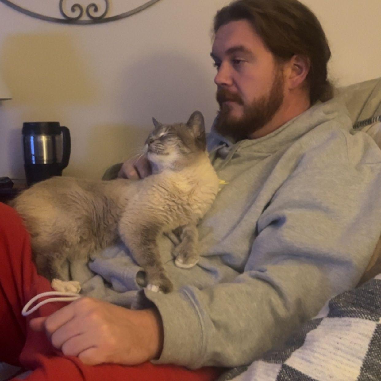 Sam and one of his family cats, Tinkerbell, watching football and struggling to stay awake
