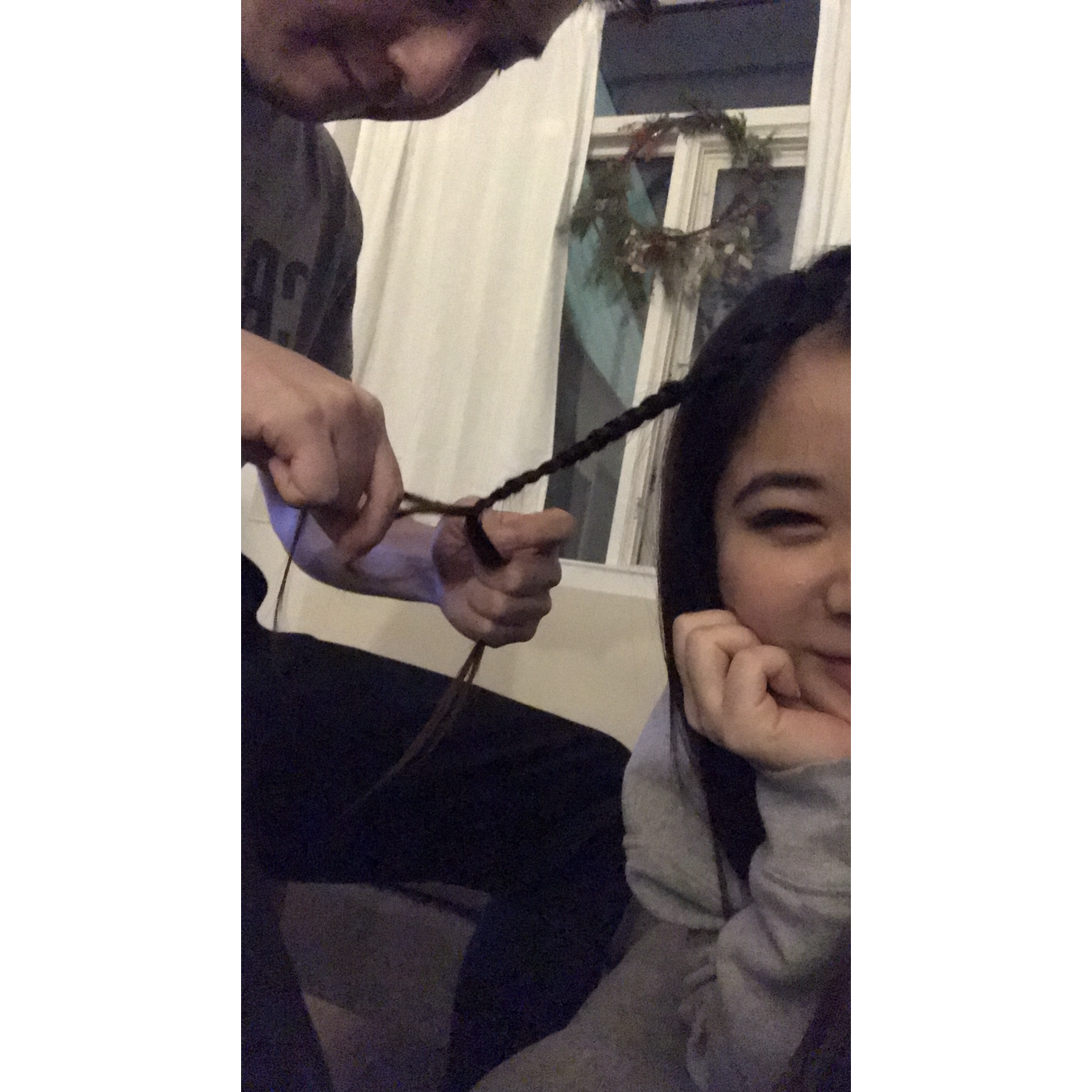 Drew braiding Jean's hair when they first started dating. Drew doesn't like this photo, but Jean does.