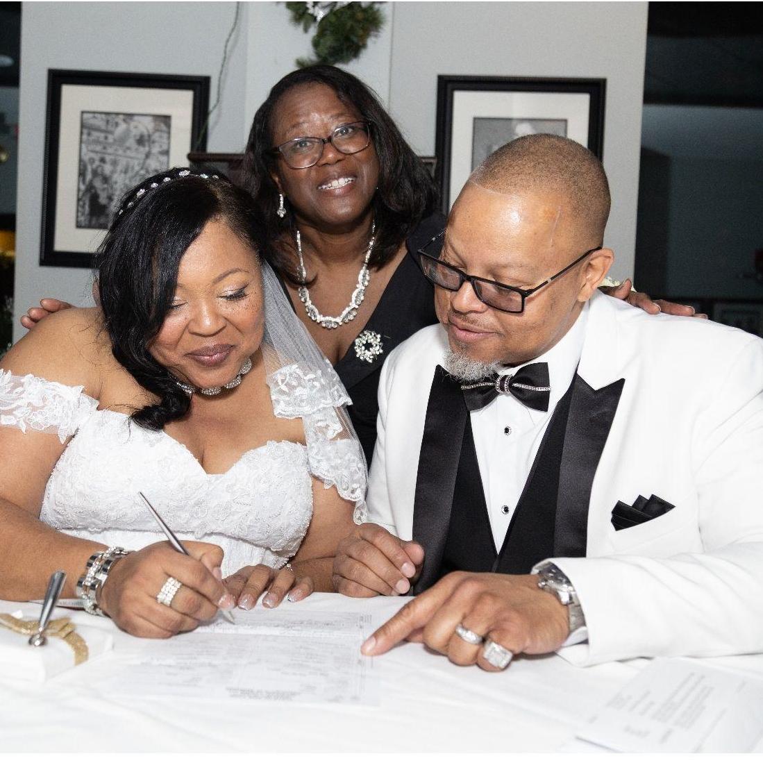 Bride & Groom & Officiant sign the official marriage license