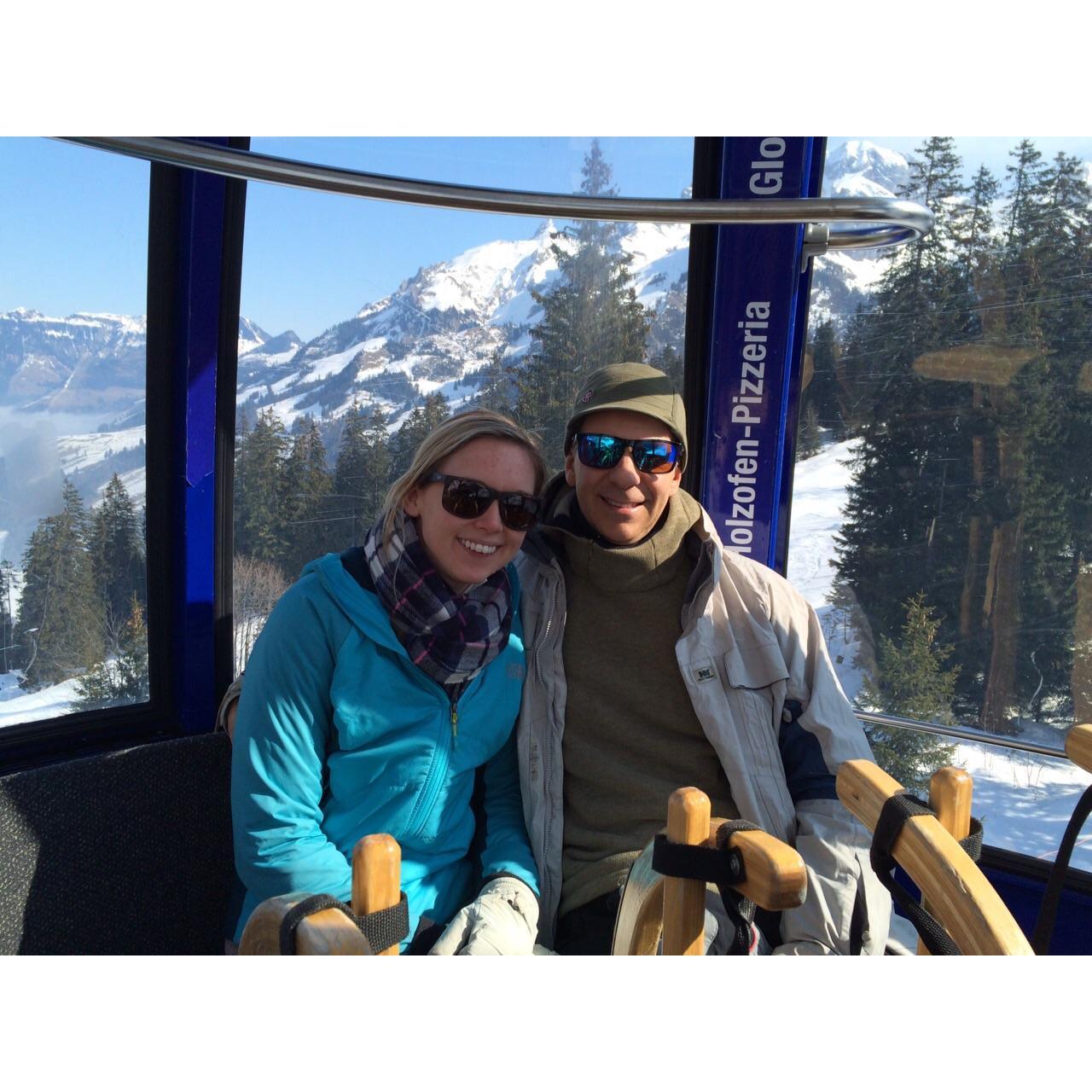 Riding a gondola up a Swiss mountain to go tobogganing.