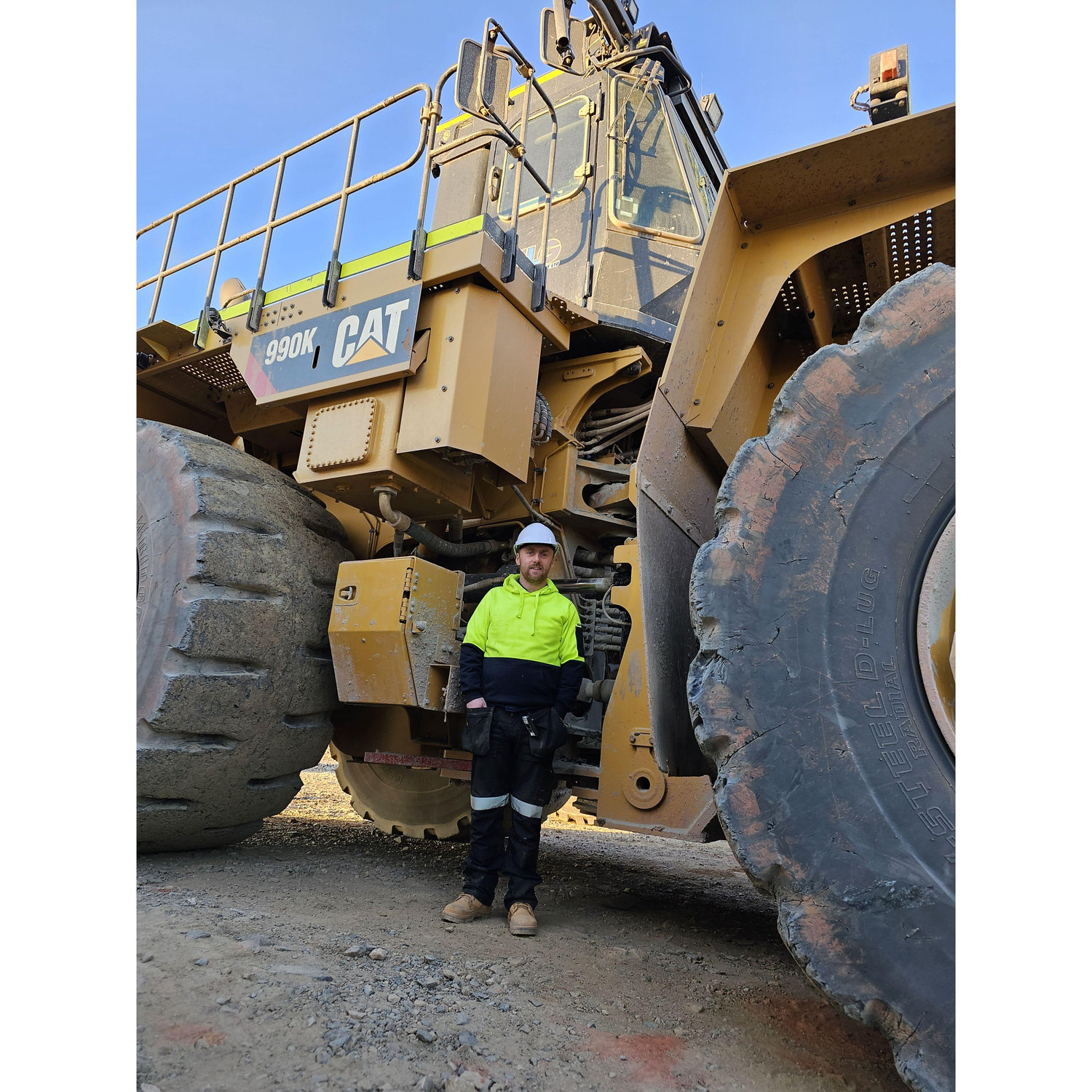 Christopher beside loader 67 which he drove during his FIFO gig