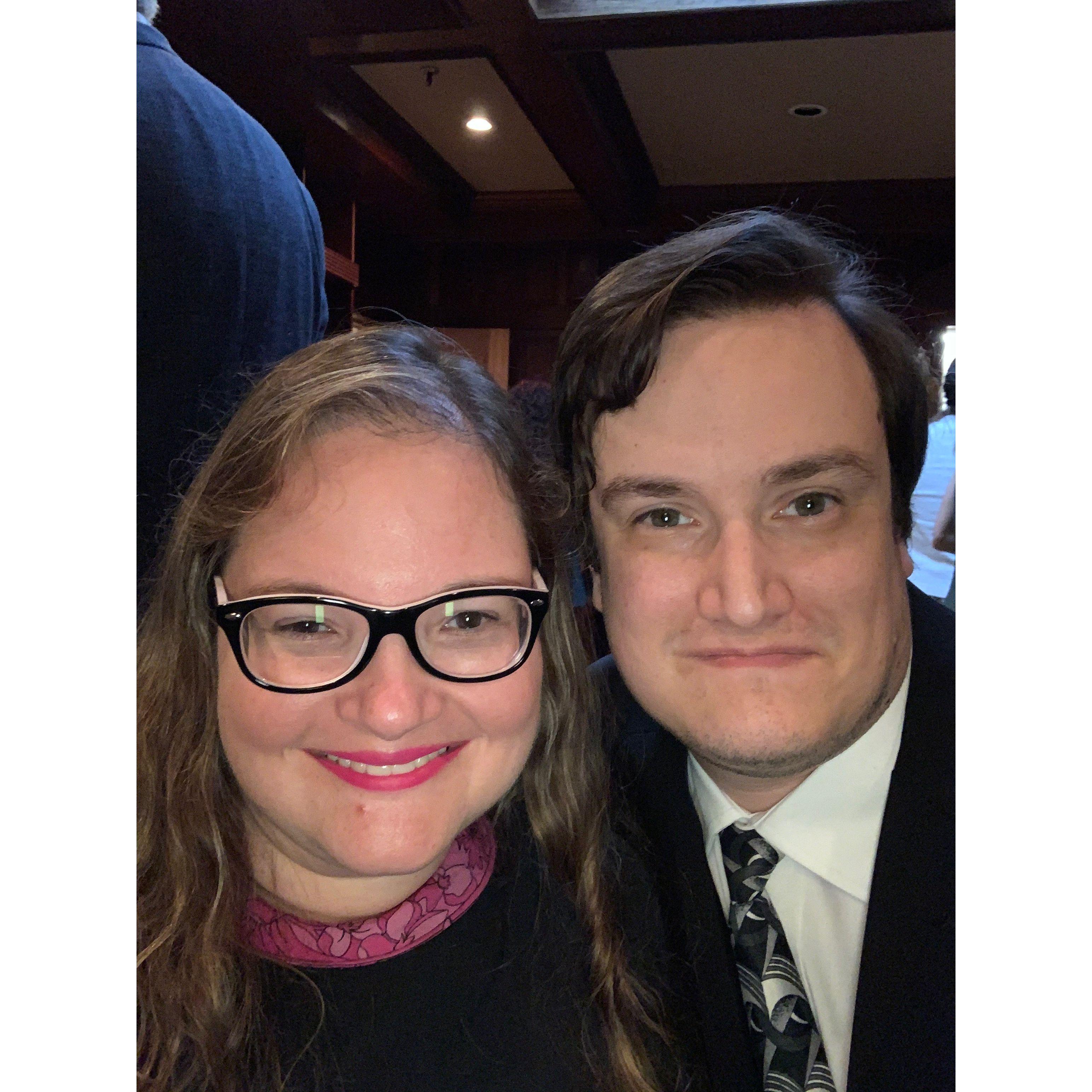 The couple all dressed up! Olivia wears a black dress with pink collar and Zac wears a suit and tie.