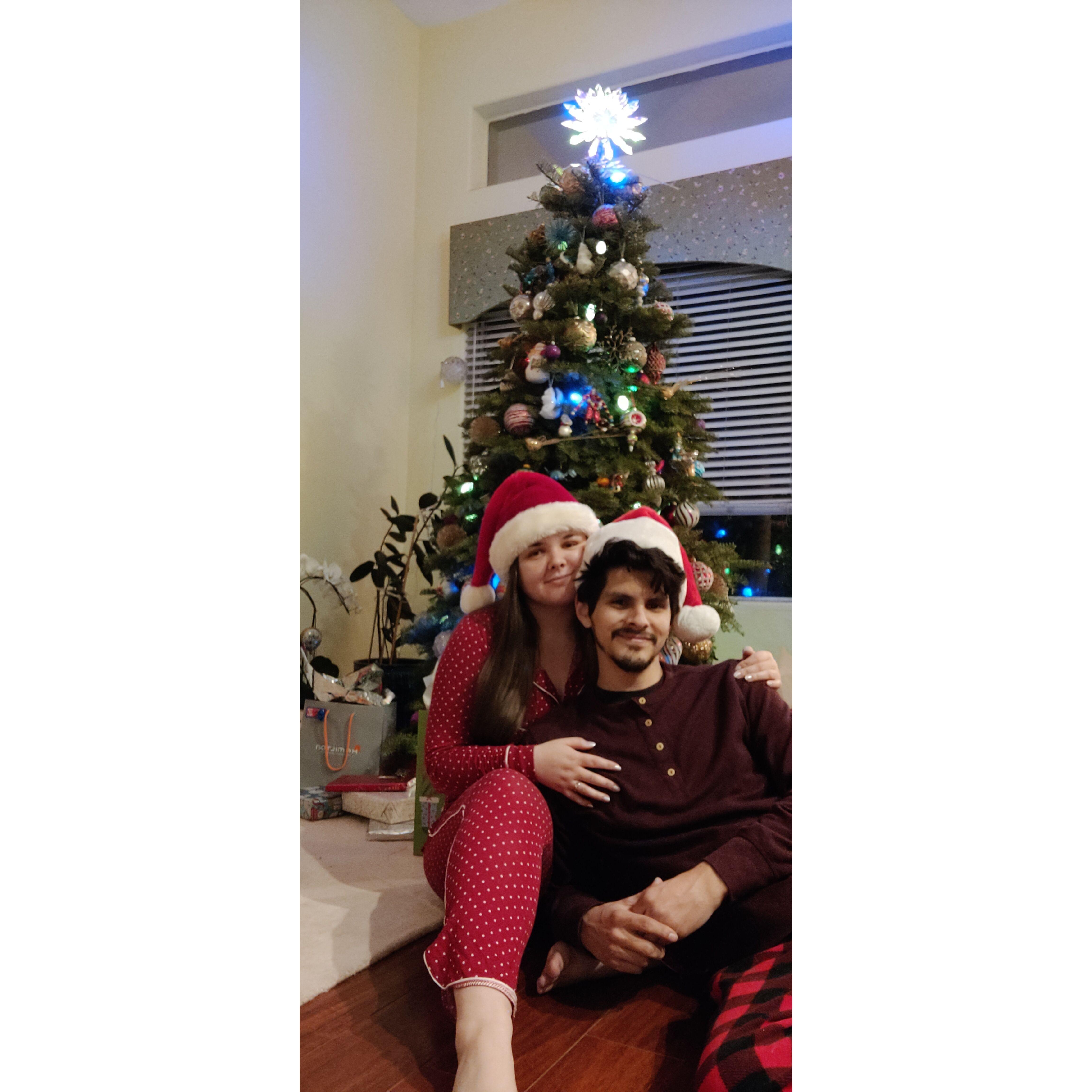 The couple in their cozy pajamas and Santa Hats on Christmas Eve 2021