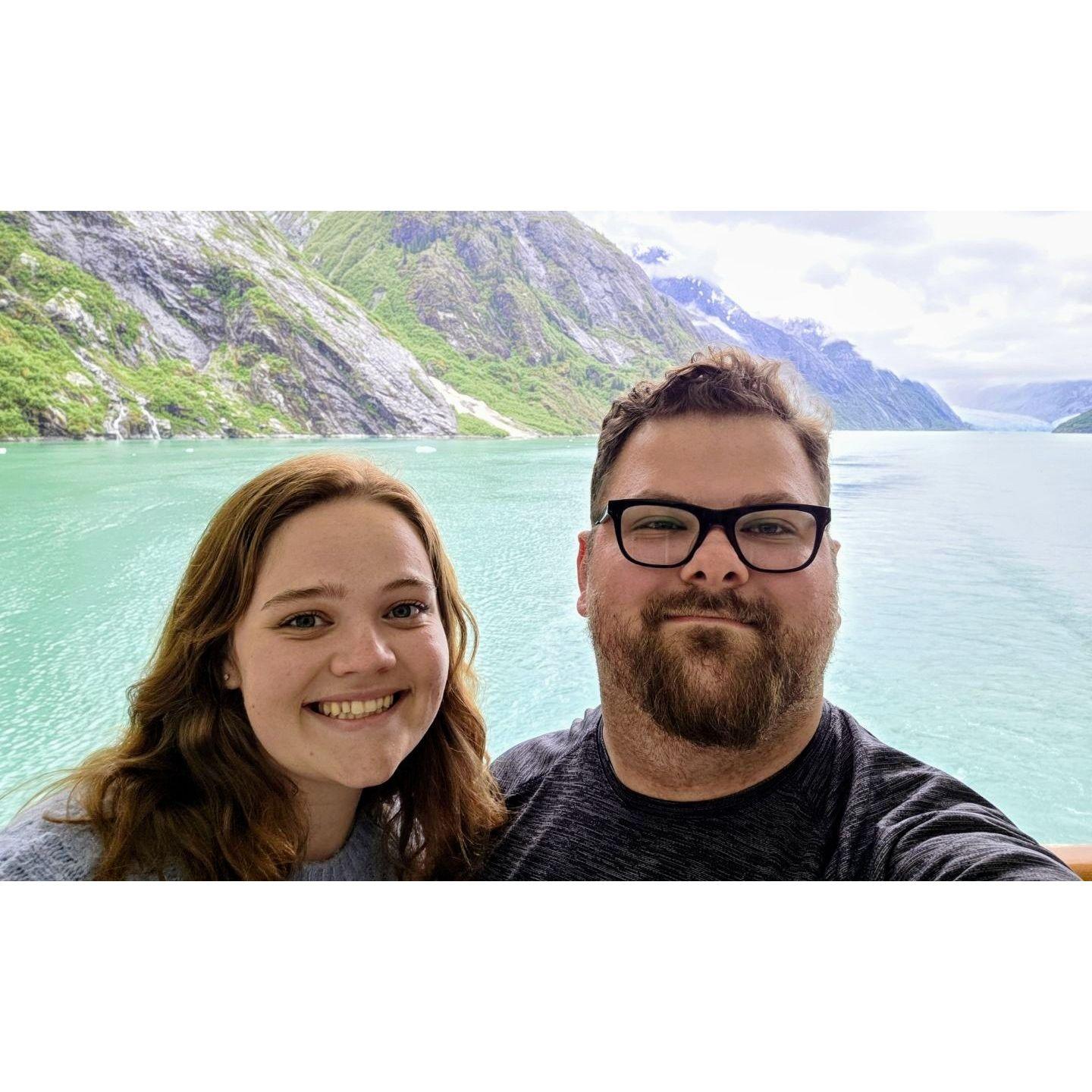 Ashley and Jeffrey standing in front of the Endicott Arm Fjord. Alaskan Cruise 2025