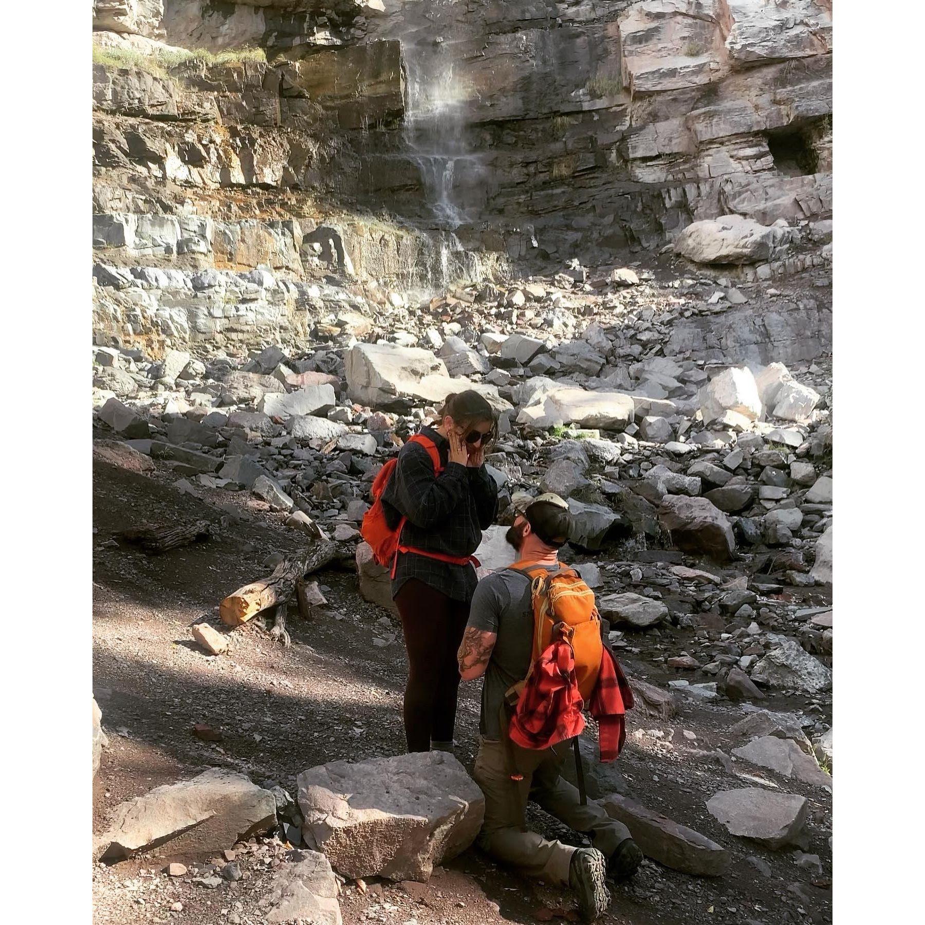 Jarod purposing to Ahren on the Ouray Perimeter Trail right by the waterfall