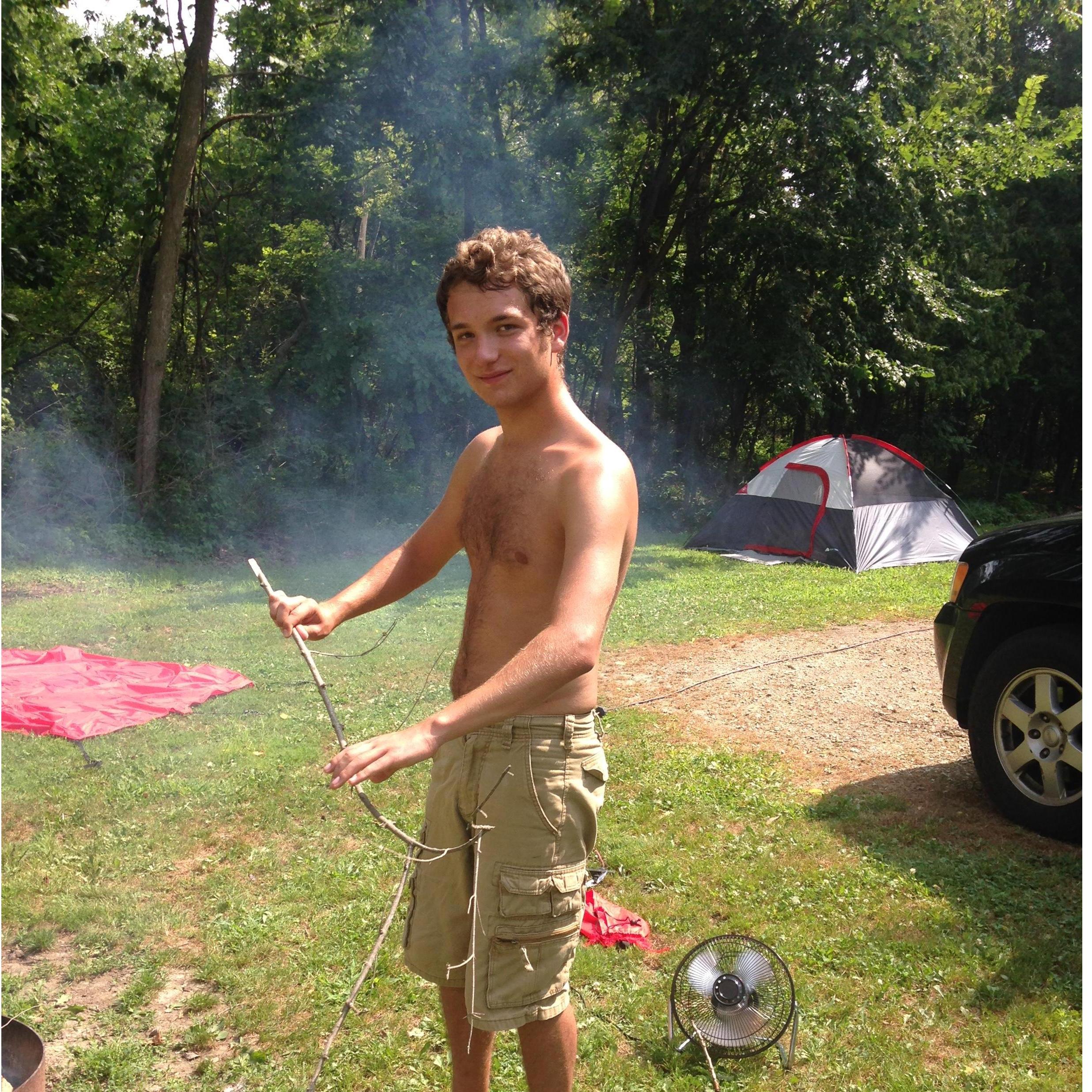 I love this picture... Alex doesn't haha :) Notice the fan behind him in an attempt for some relief while cooking over a fire in 90 degree weather.