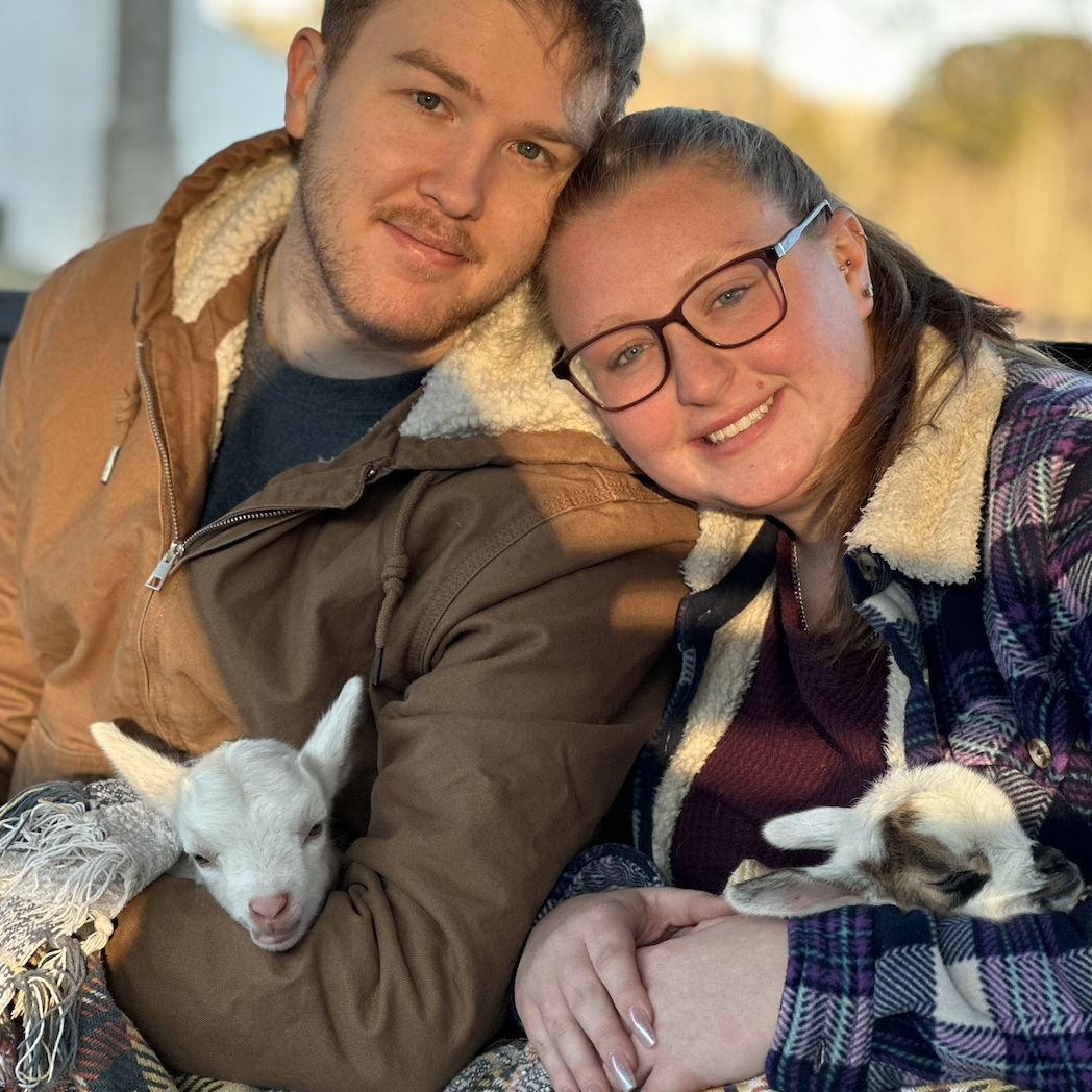 Michael and Catherine holding baby goats at the Good Place Farm