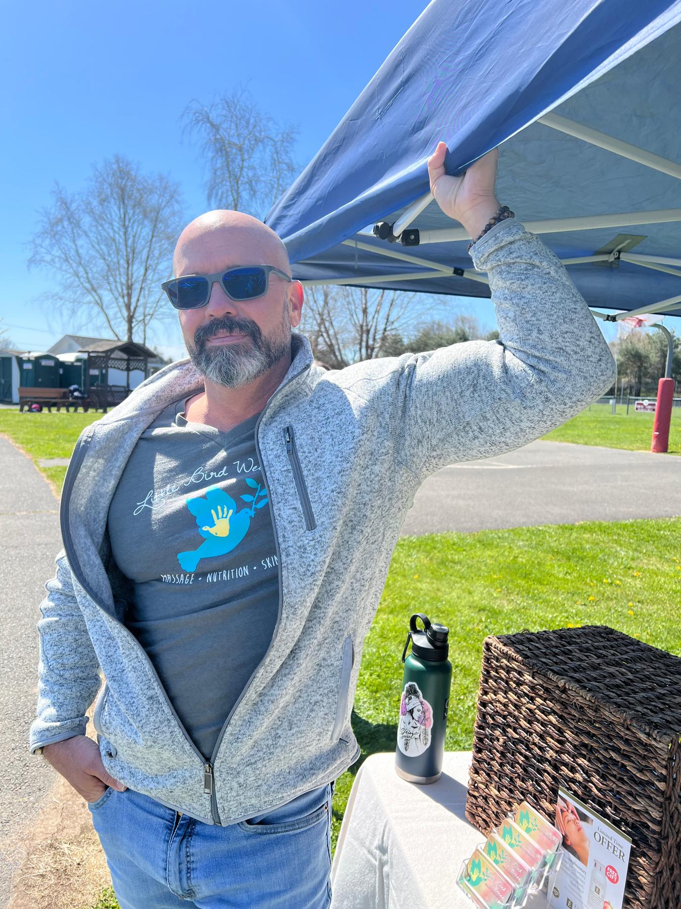 Helping to hold down (quite literally) the Little Bird Wellness tent during a windy event
