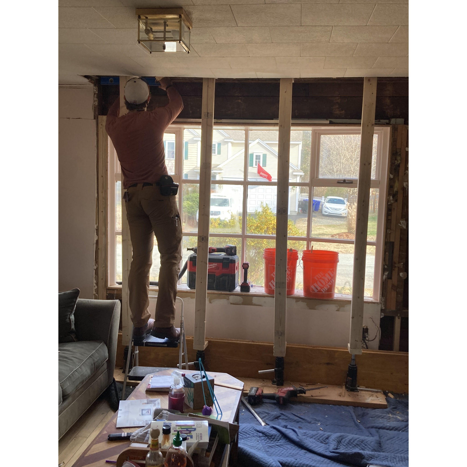 Jacob installing a structural header above the bay window so our house doesn't fall down.