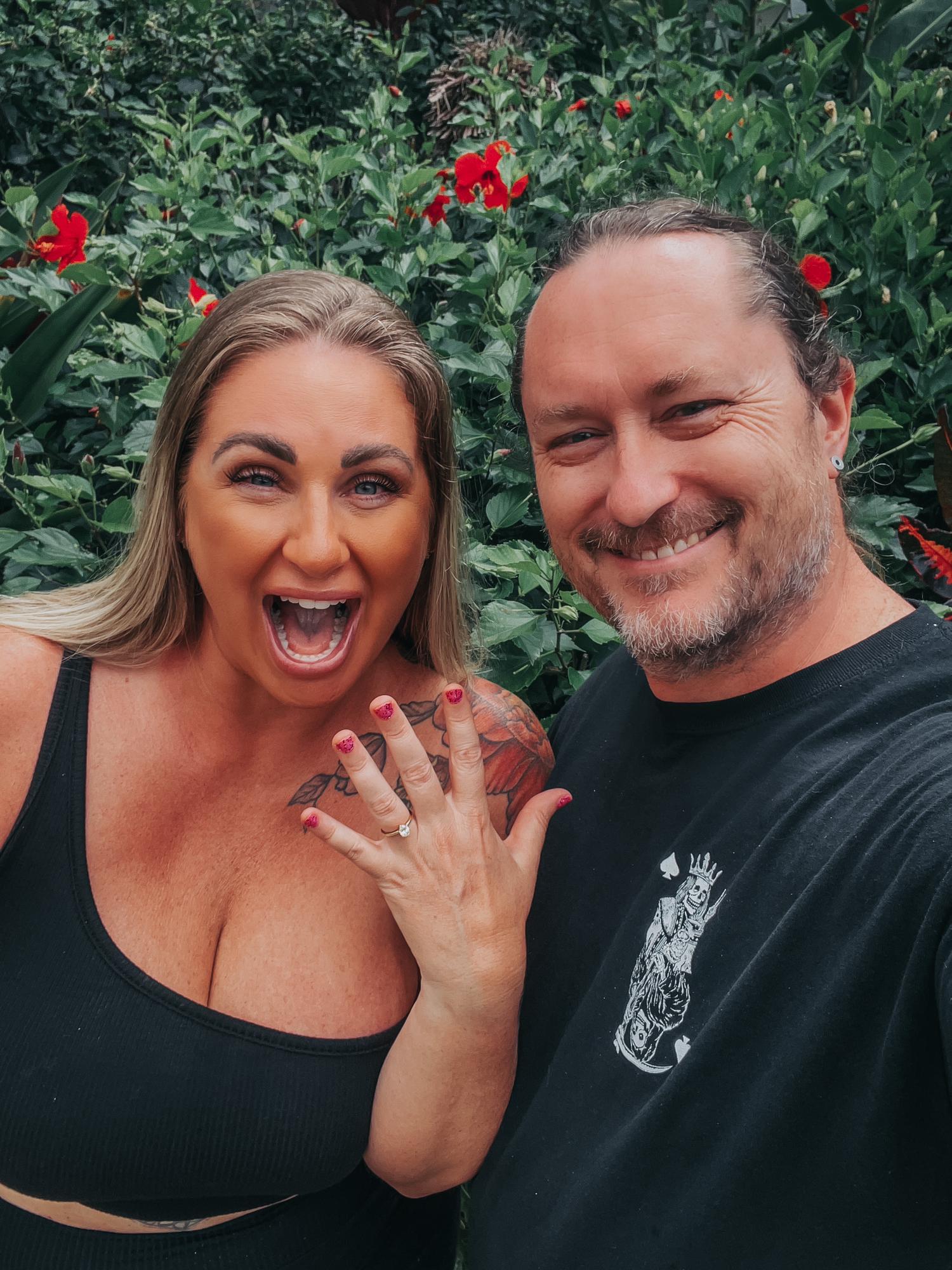 We got engaged February 19, 2022 after almost THREE years together. He picked the perfect ring. He proposed in front of a bunch of our friends at sunset. She cried & said yes. It was magic!