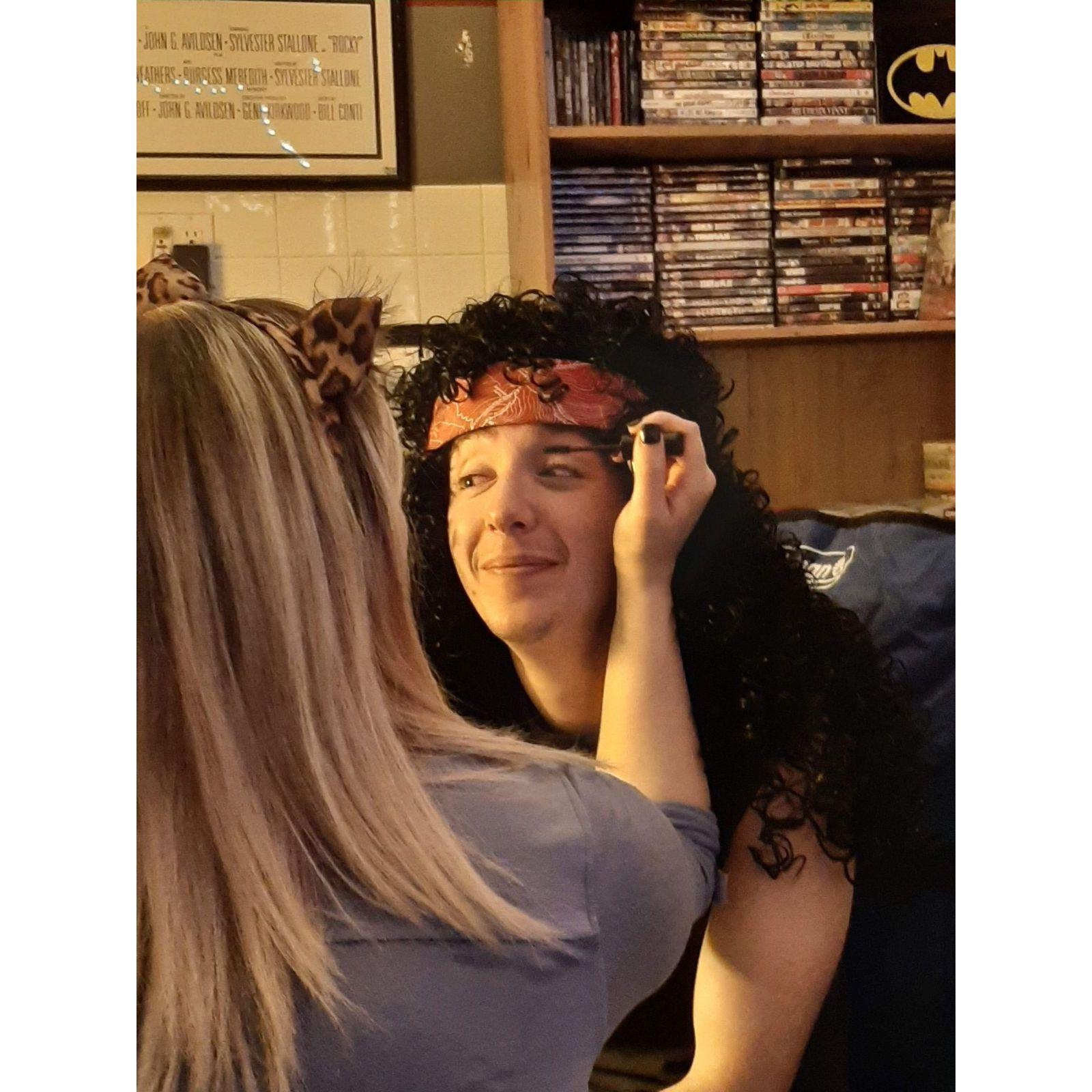 Our first encounter outside of work. Jenny is applying John's rock star make-up for his 2020 Halloween costume.