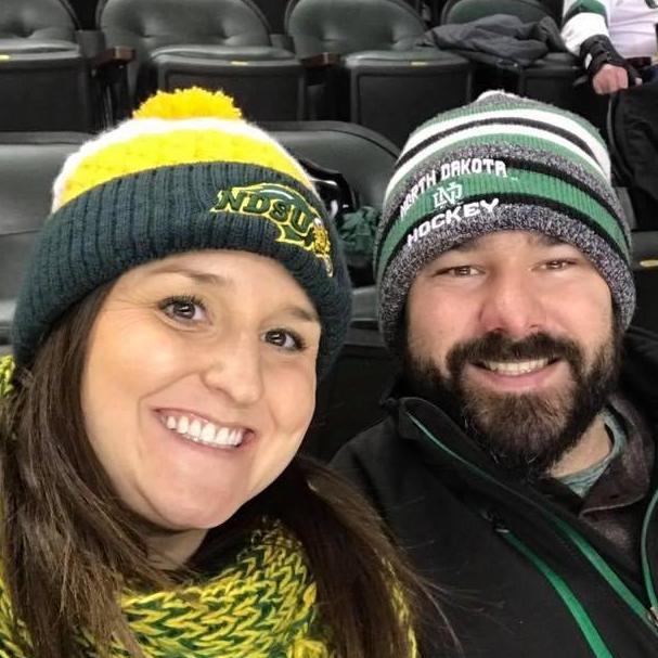 We love our sports teams! Leslie is an NDSU Bison fan, and Chase is a UND Hawks fan. Leslie loves wearing her Bison gear to Hawks games, and they even got on the kiss cam!