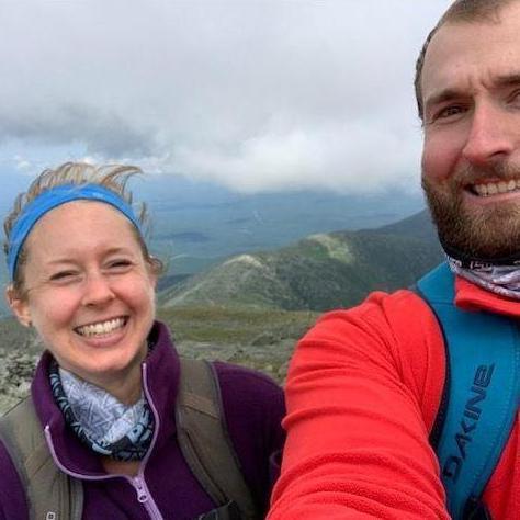 The faces of two people who just reached the peak of Mt. Washington
