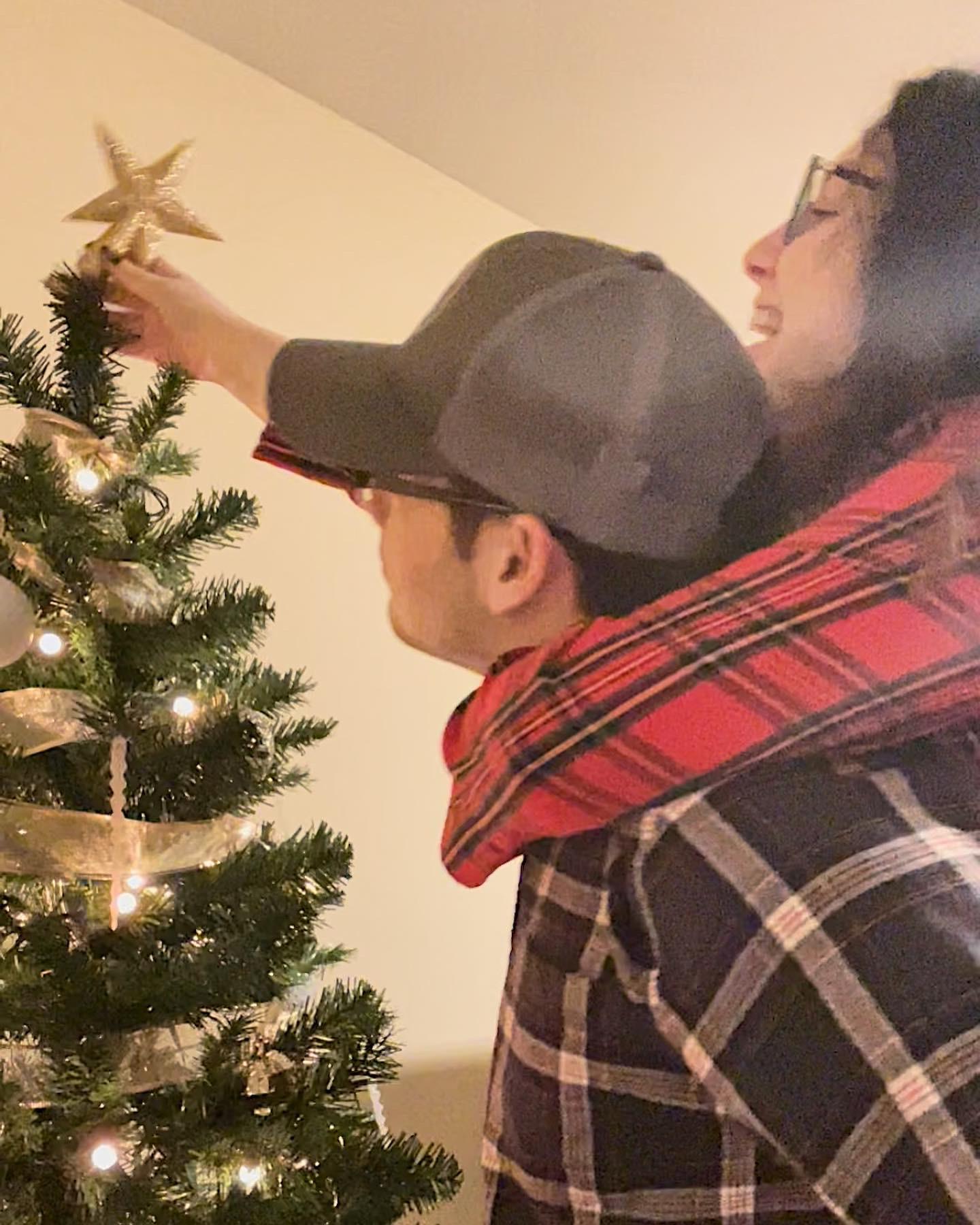 Hanging the star on our first Christmas tree.