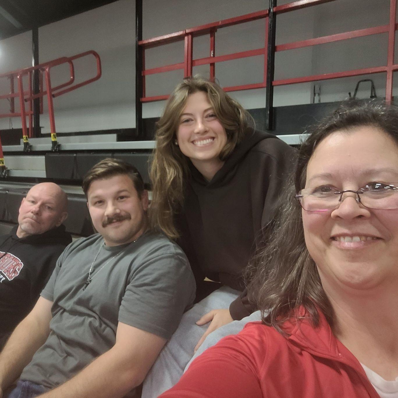 Emma and Austin watching Calvin's wrestling match with Austin's parents