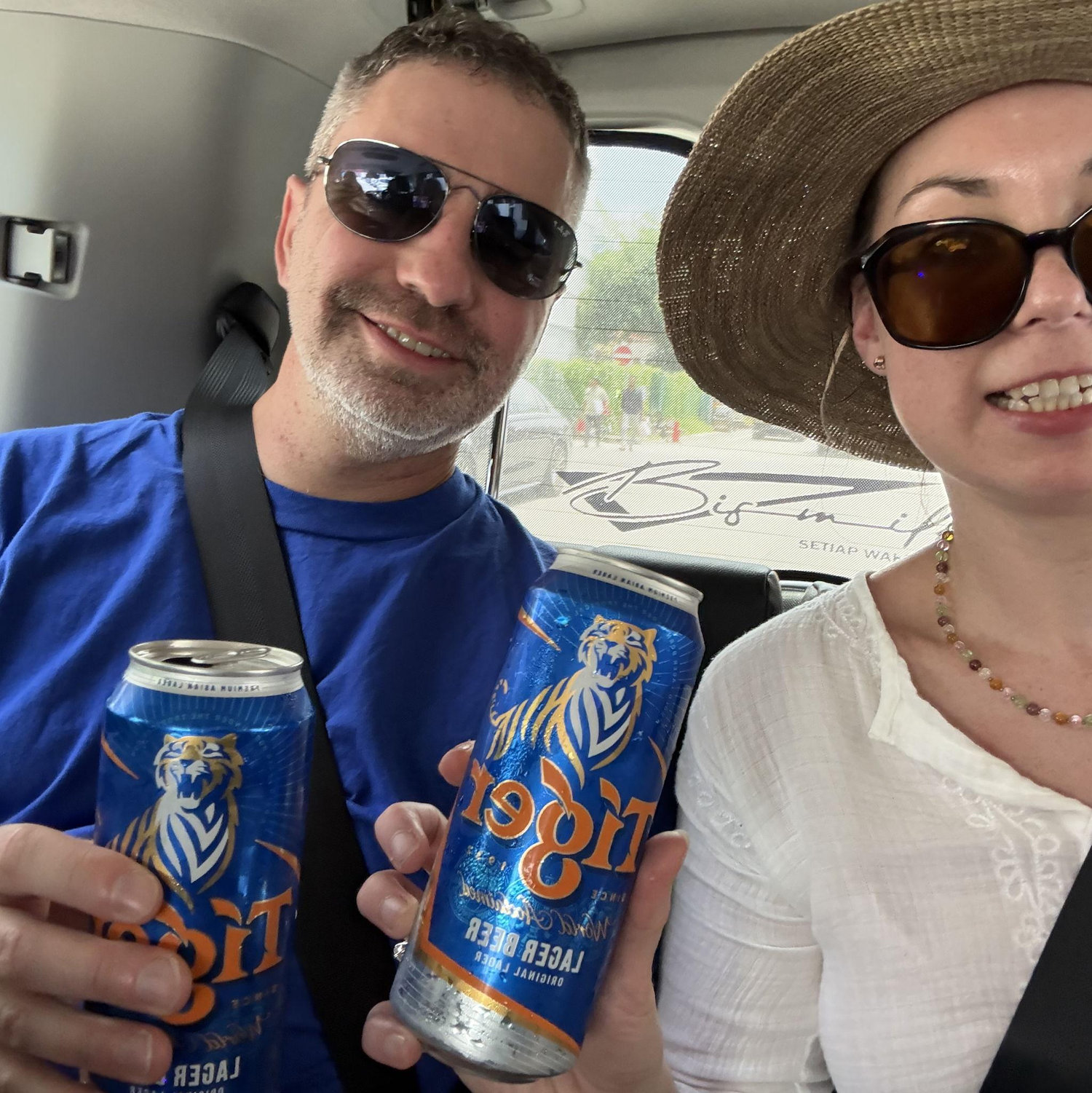 (At the insistence of our tour guide) drinking Tiger Beers in the back of a van in Singapore.