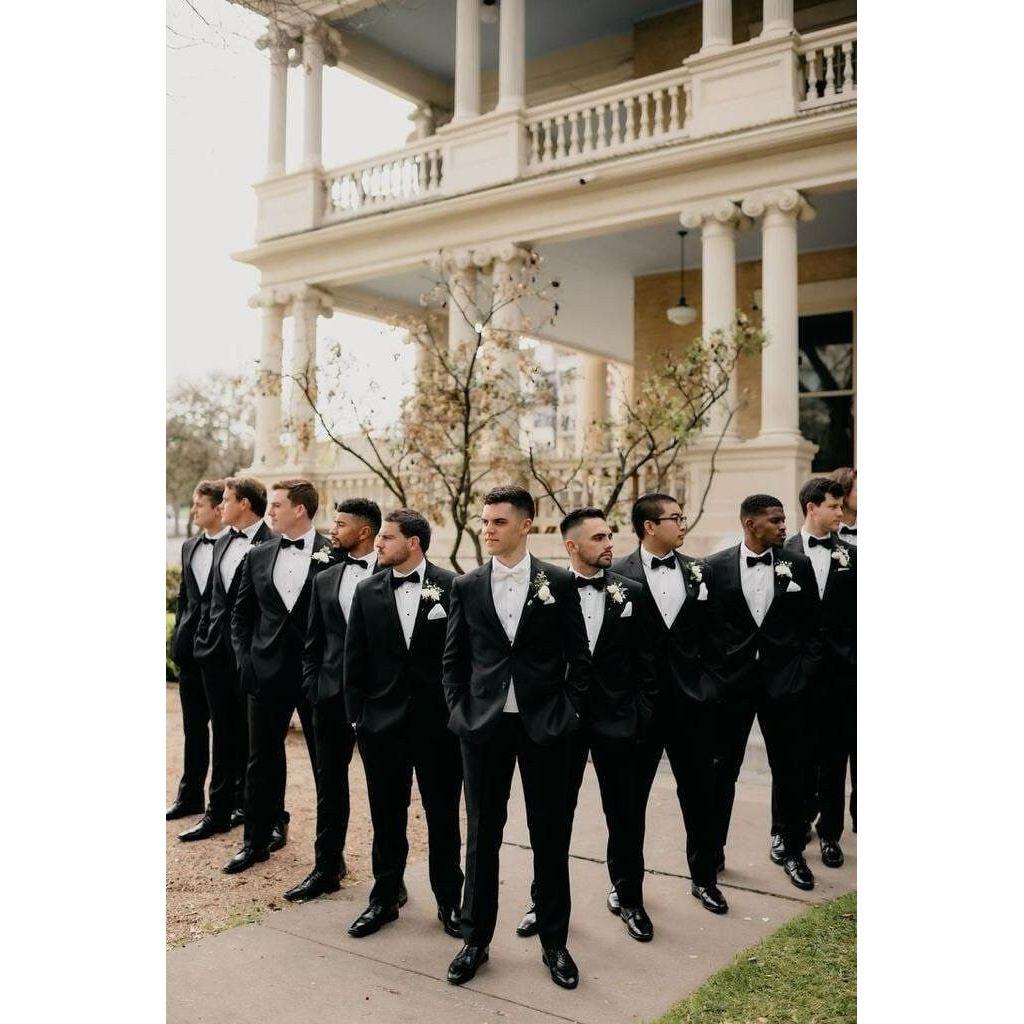 Gentlemen:
A classic black suit is requested, paired with a black tie or bow tie for that polished, sophisticated look. You can’t go wrong with a crisp white shirt under your suit and black shoes.