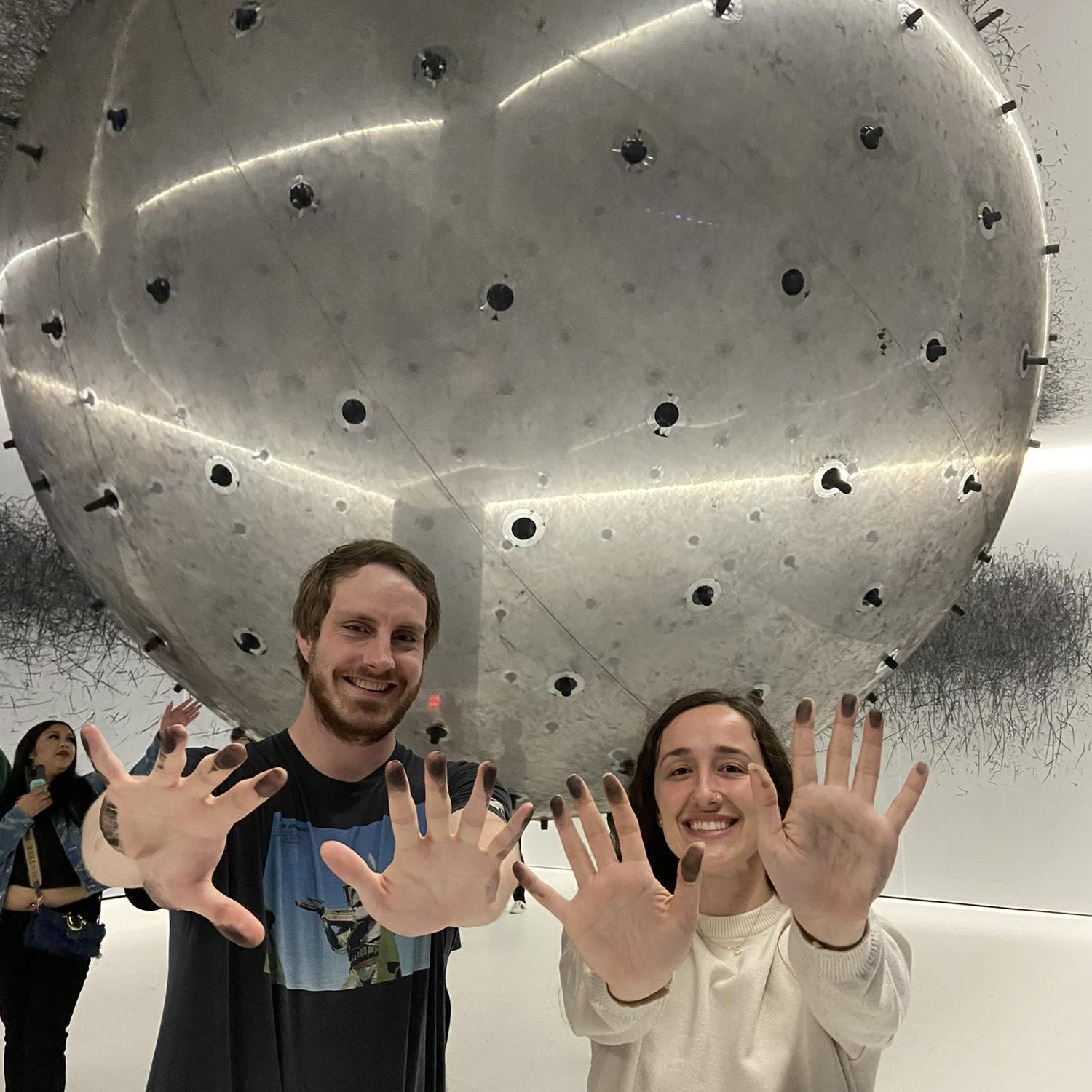 Spring 2025, at an interactive art museum in the city, pushing around a giant balloon covered in charcoal!